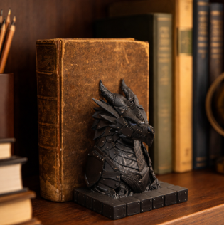 Armoured dragon book stand displayed against a book on a shelf